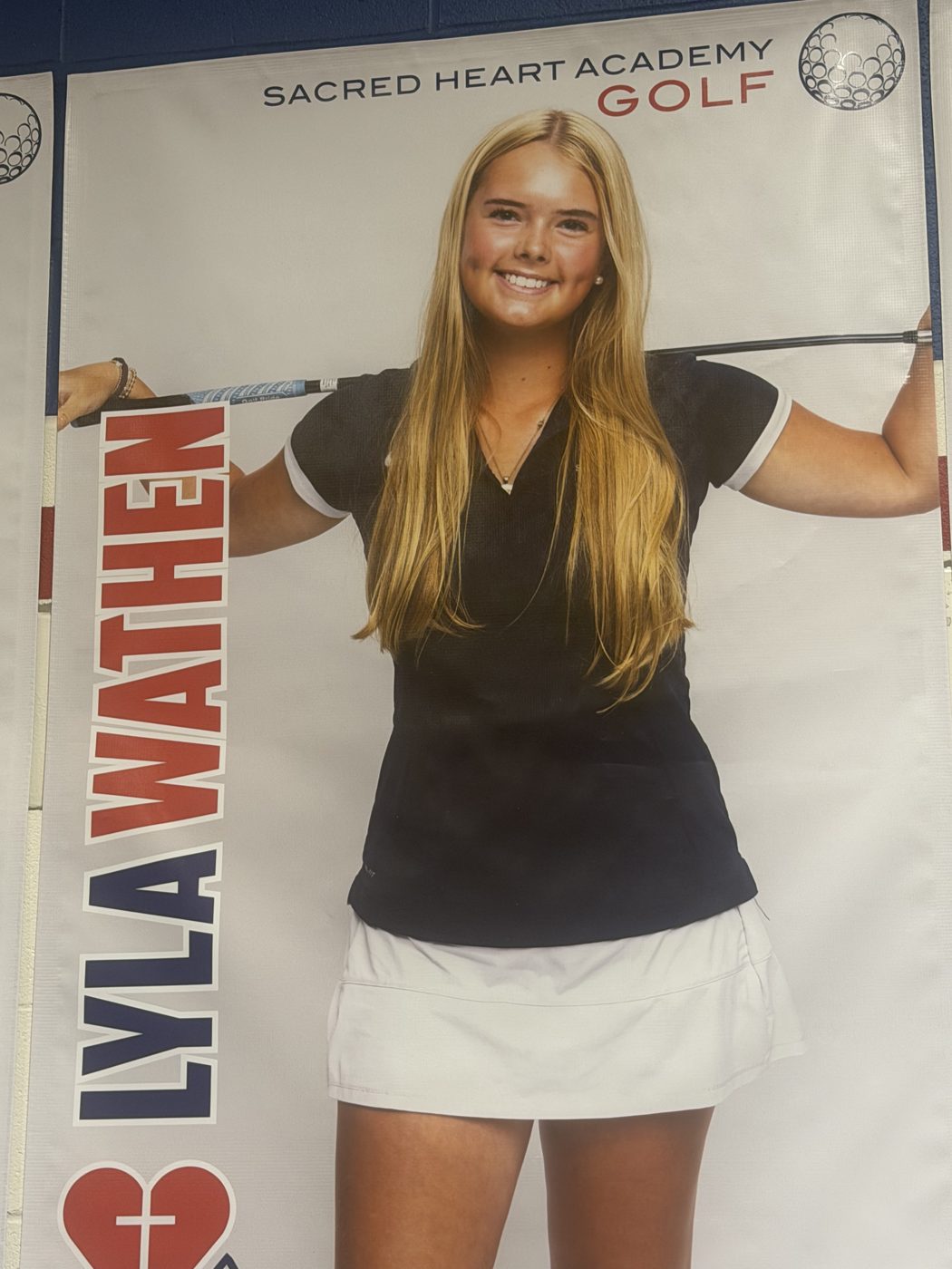 Lyla with her Sacred Heart Academy Golf banner